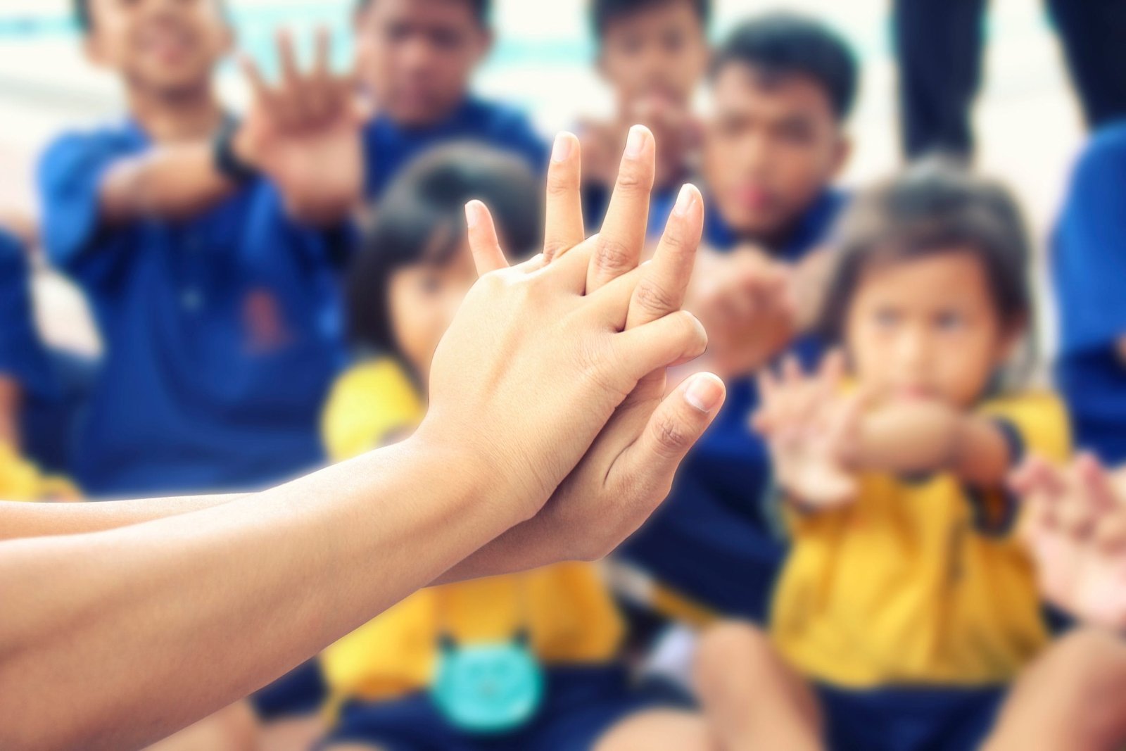 A group of children with their hands up in the air.